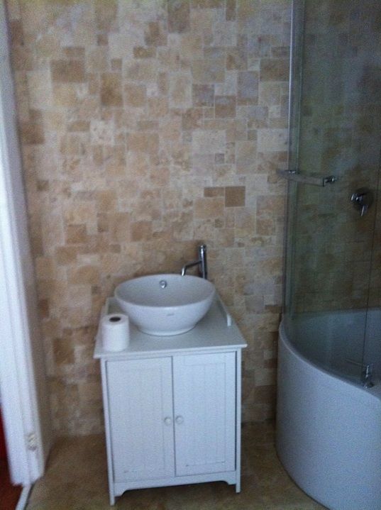 Stone-tiled bathroom with a bowl basin