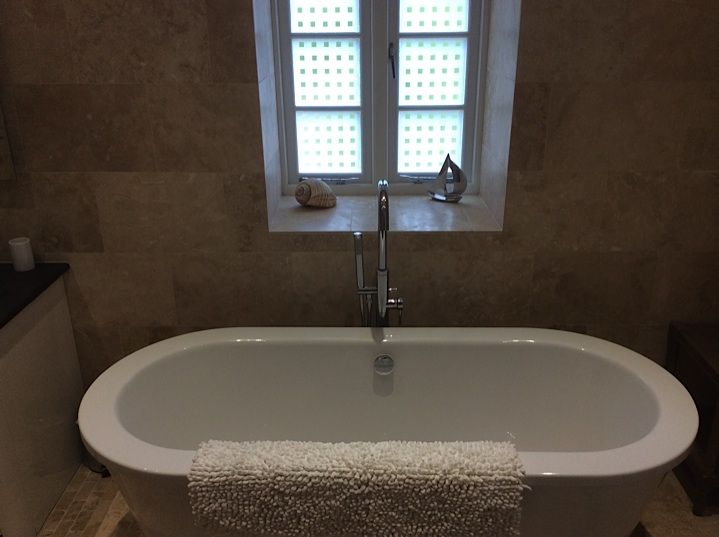 Freestanding bath in a tiled bathroom fitted by Exmoor Heating